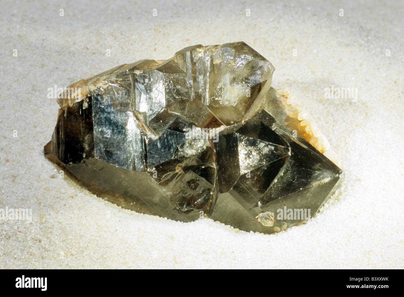 Smoky Quartz, Silicon Oxide (SiO2), hexagonal crystals on sand Stock
