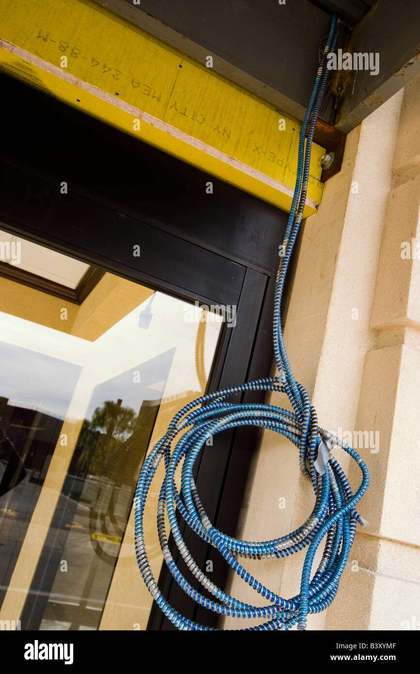 Coiled electrical cable hanging outside a building Stock Photo Alamy
