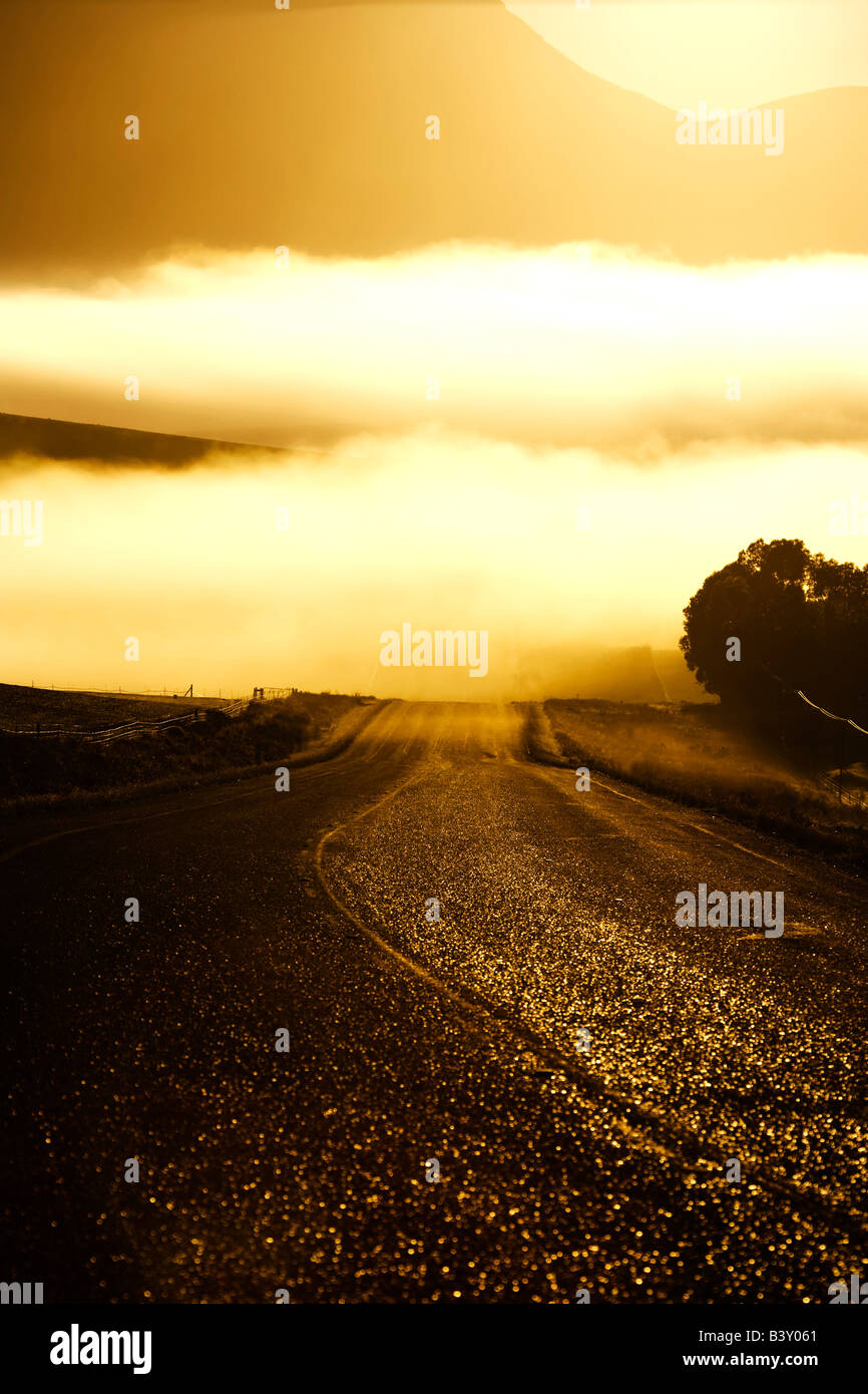 Road at Sunrise on a Misty Morning Stock Photo