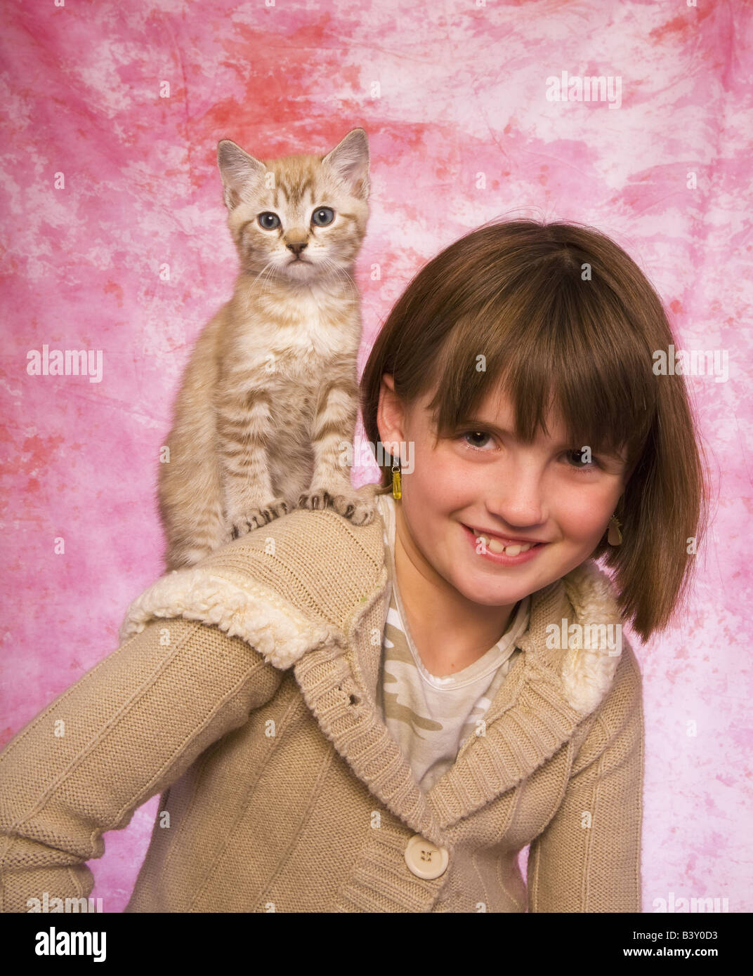 Young girl with cute kitten on her shoulder with pink ...