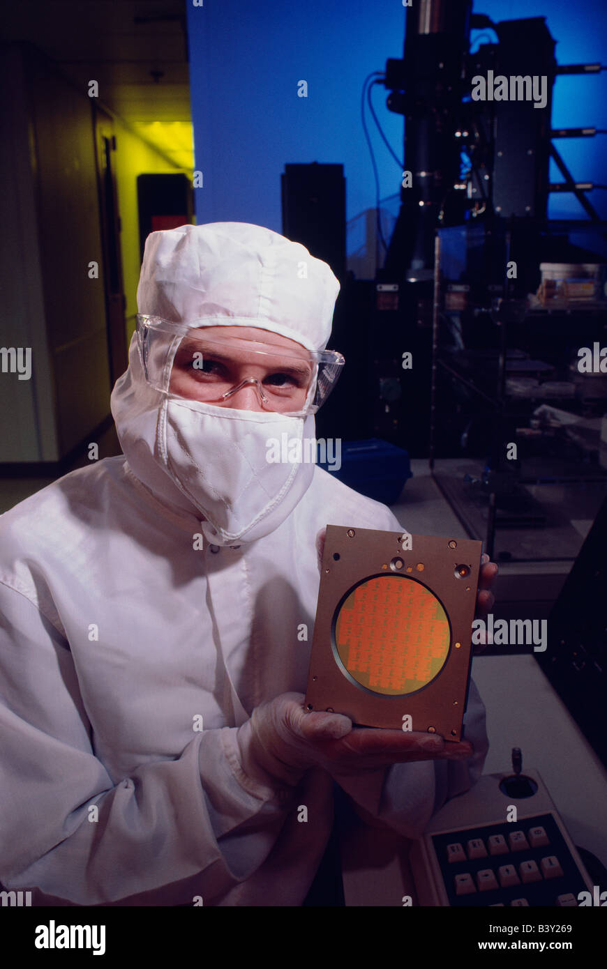 Technician in clean room with silicon wafer used to make computer chips Stock Photo