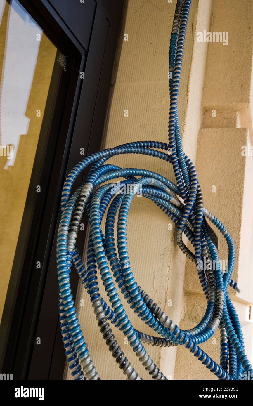 Coiled electrical cable hanging outside a building Stock Photo Alamy