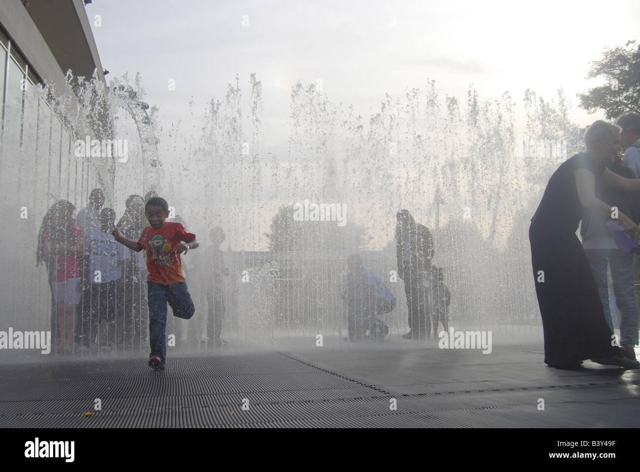 Fountain children play water game wet London Southbank Stock Photo