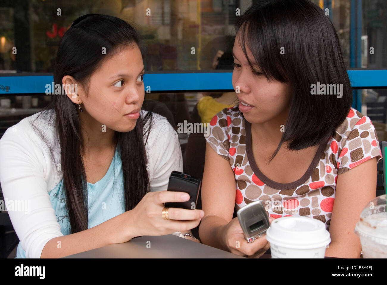 Woman texting at a coffee shop Stock Photo - Alamy
