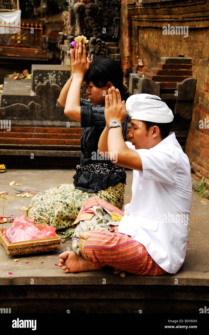 balinese couple praying at family temple , ubud , bali , indonesia Stock Photo