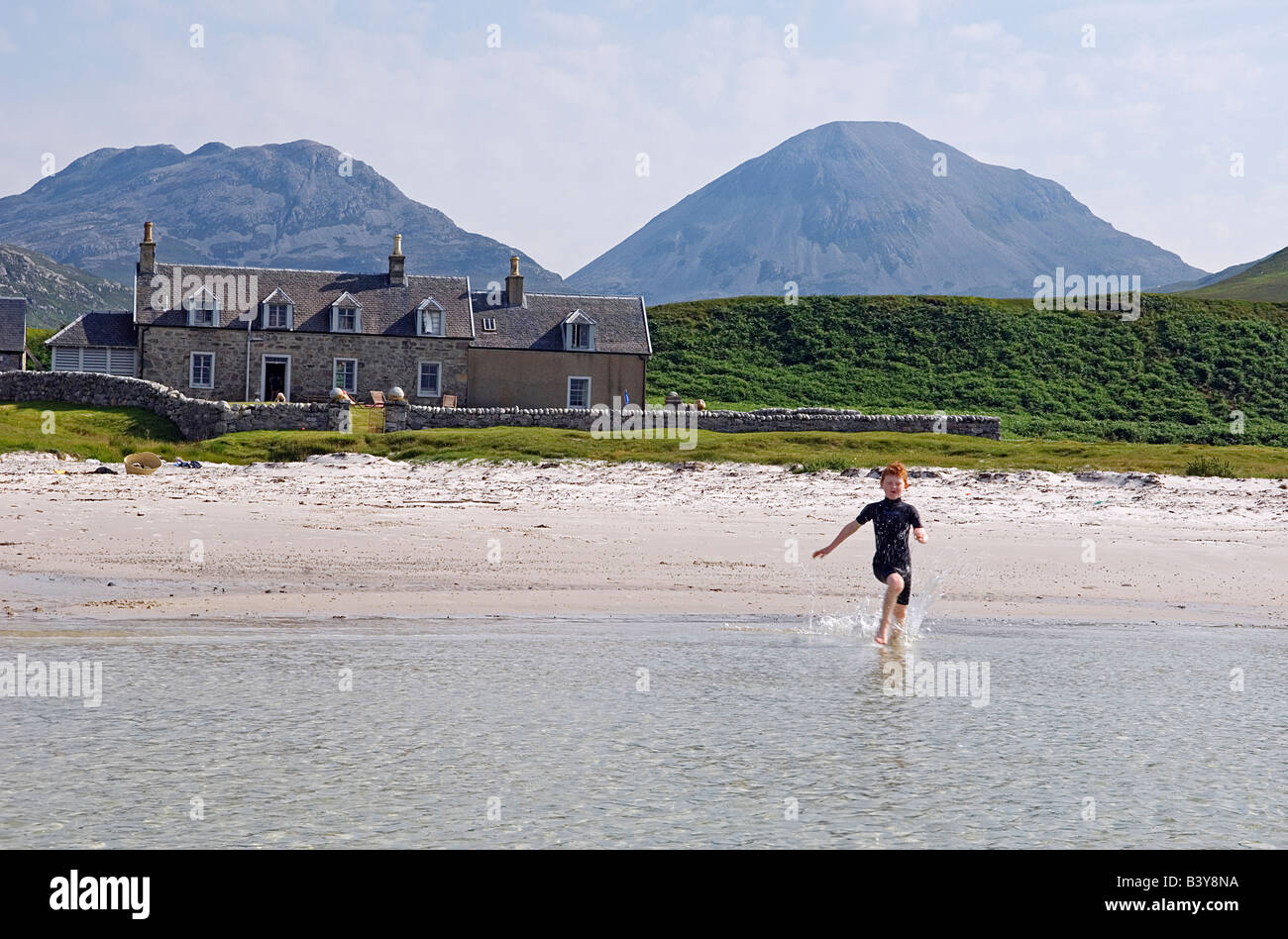Scotland, Inner Hebrides, Jura. A boy runs in to the water of Loch