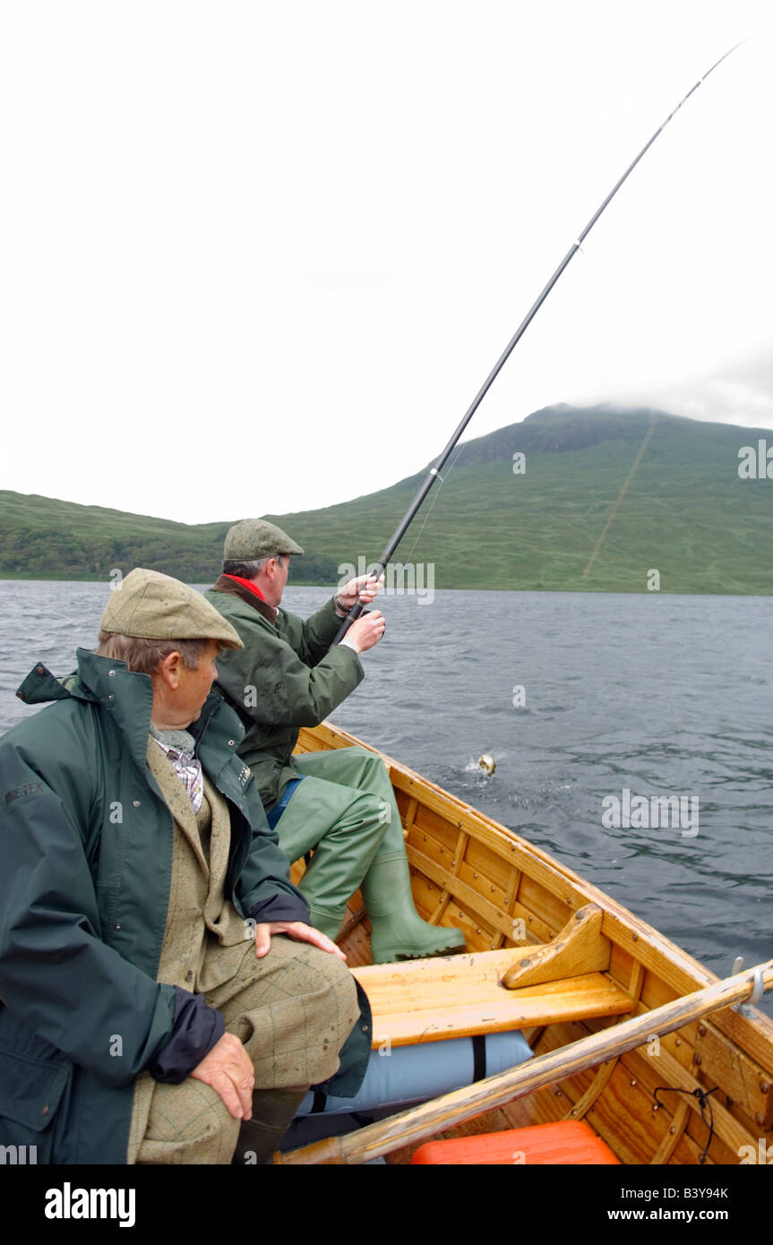 Scotland, Hebrides, Mull. A fisherman reals in a brown trout caught on