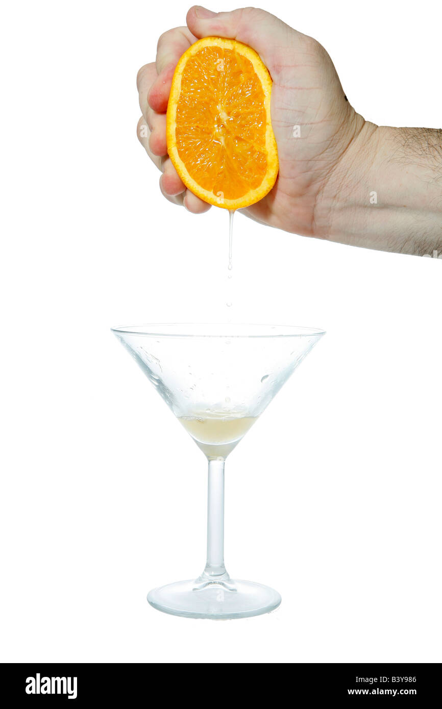 Close up of a hand squeezing an orange making homemade orange juice