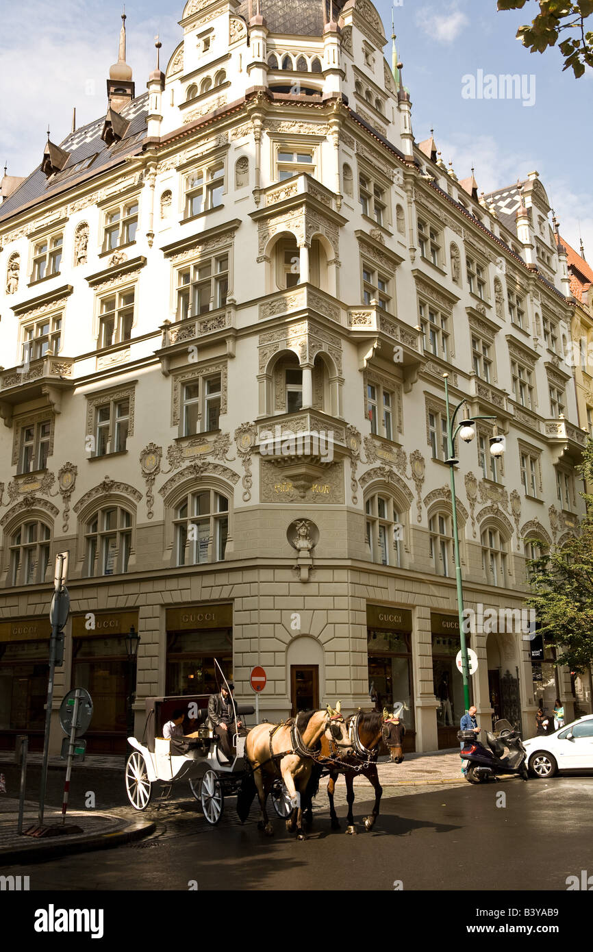 A coach in front of the restored front of a commercial building in Prague Stock Photo