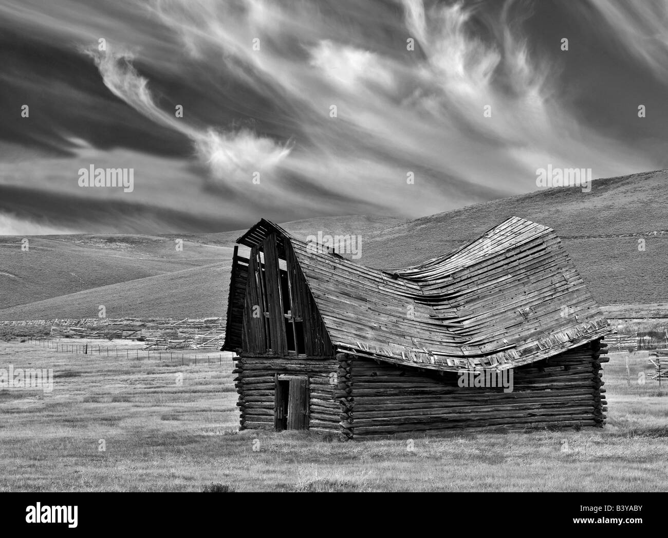 Fallen down barn with wispy clouds Montana Stock Photo