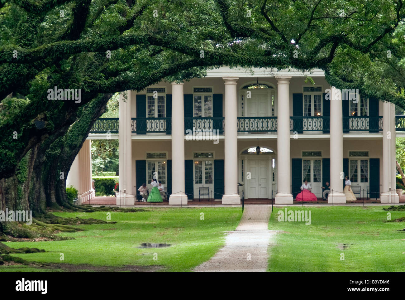 USA, Louisiana, St. James Parish, Vacherie.  View of Oak Alley Plantation with women dressed in antebellum costumes on the porch Stock Photo