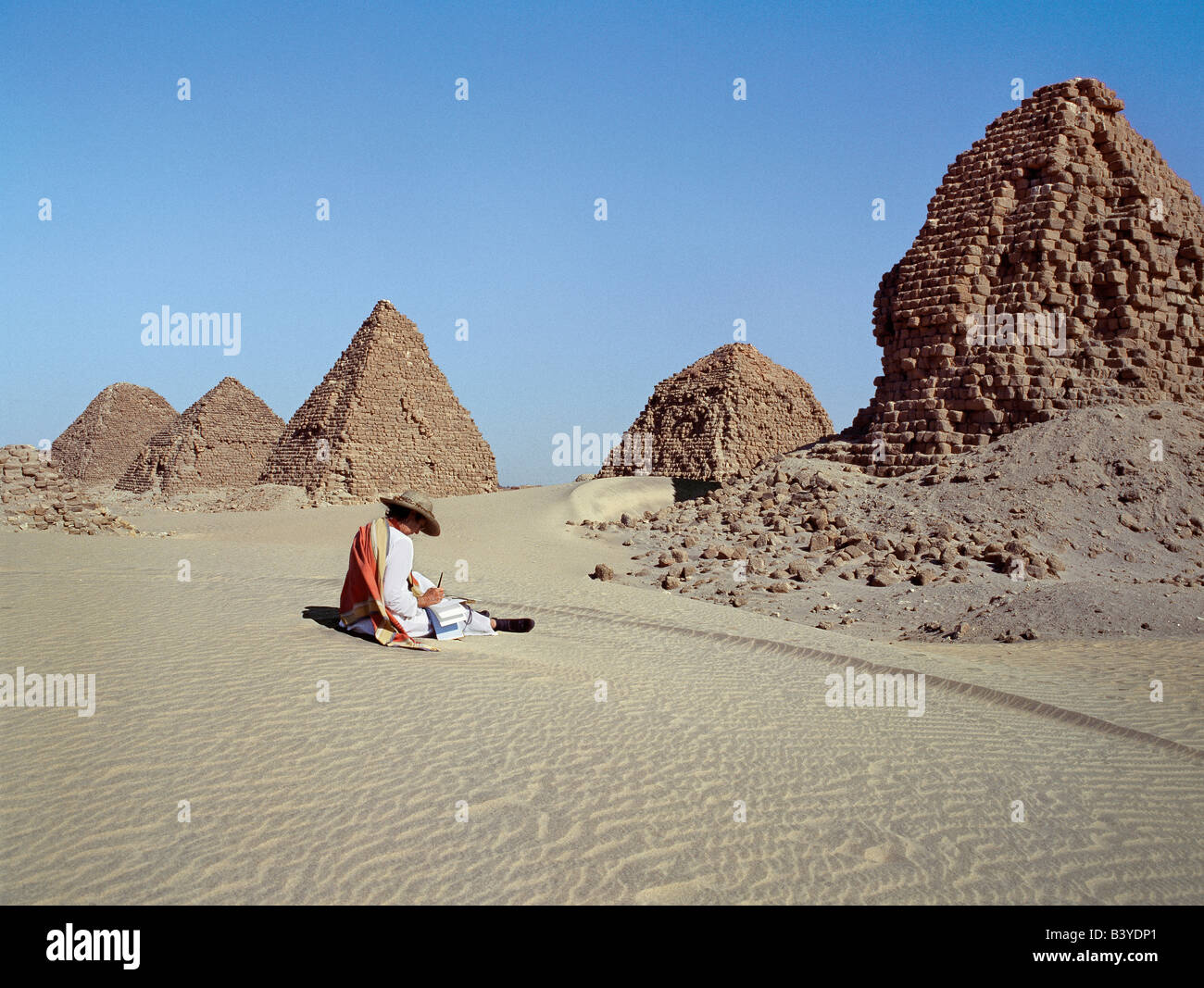 Sudan, Sahara Desert, Nuri. A tourist at the ancient pyramids at Nuri date between 700BC and 300BC. Nineteen kings and fifty-three queens from all the dynasties of the Kingdom of Cush are buried in these pyramids including Taharqa (690BC-664BC), the famous Black Pharaoh who ruled over Egypt in the 7th century BC until the Assyrians expelled him from Egypt.In 300BC the capital of the Kingdom of Cush and the royal burial grounds were moved to Meroe due to conflict with Egypt whose expeditionary forces sacked Napata in their drive south. . Stock Photo