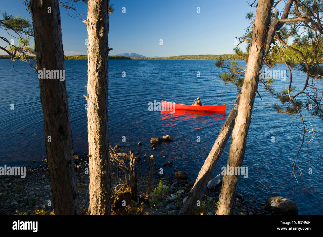 A man paddles his canoe on Seboeis Lake near Millinocket, Maine. Mount