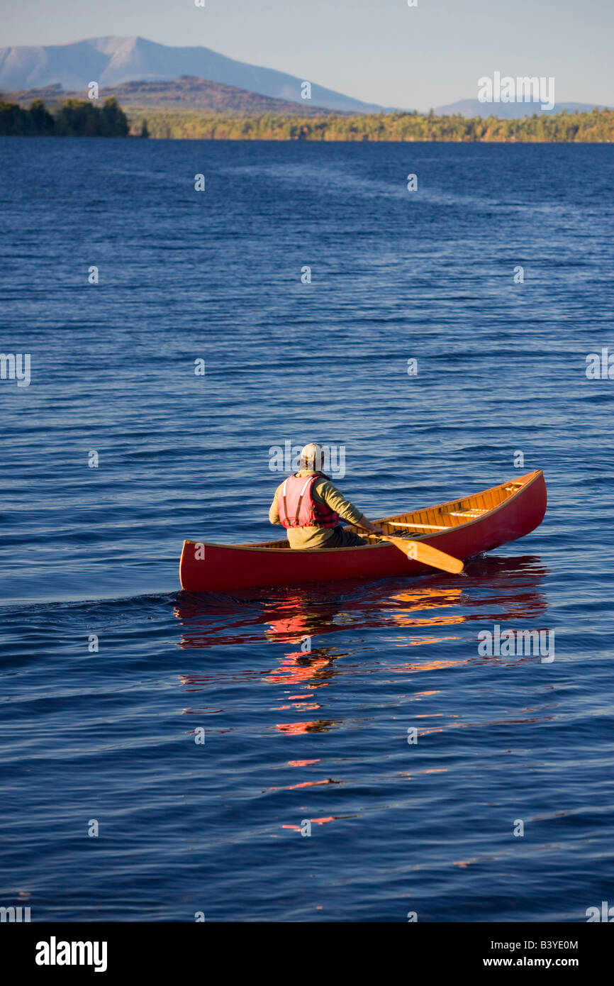 A man paddles his canoe on Seboeis Lake near Millinocket, Maine. Mount