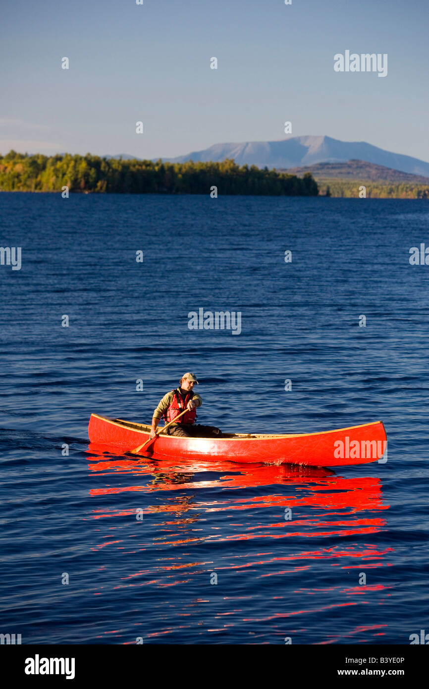 A man paddles his canoe on Seboeis Lake near Millinocket, Maine. Mount
