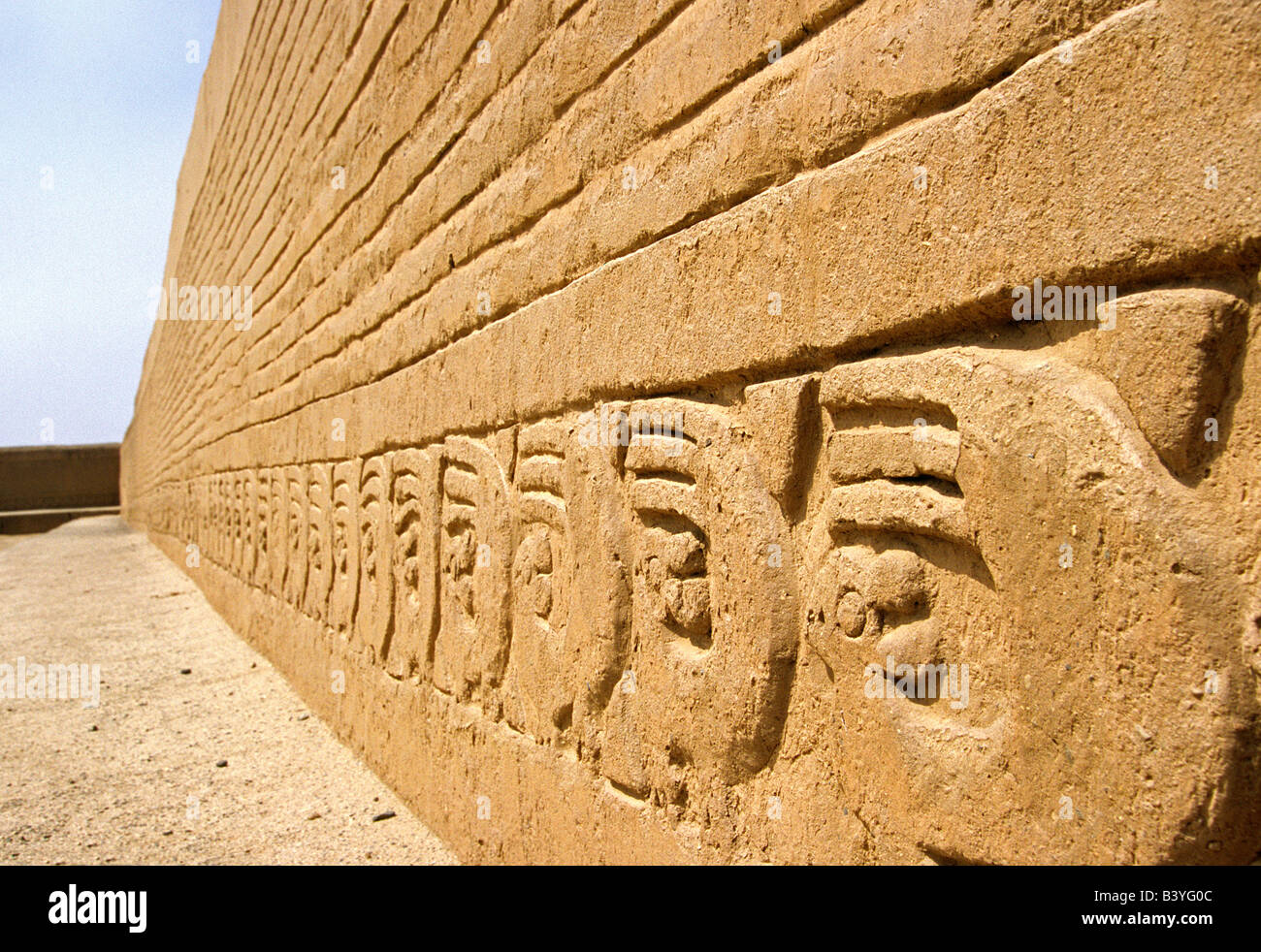 Peru, Trujillo, Chan Chan. The adobe walls of the Ceremonial Courtyard in the Tschudi Complex, decorated with bas relief designs featuring sea otters and waves. The Complex is part of the ancient Chimu site of Chan Chan, in northern Peru Stock Photo
