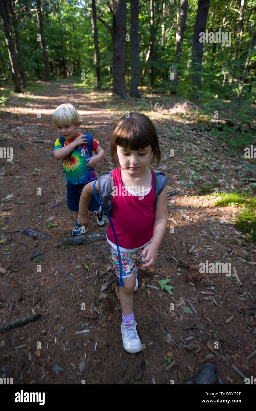 A young brother and sister go hiking in North Hampton, New Hampshire.  Near the headwaters of the Winnicut River. (MR) Stock Photo
