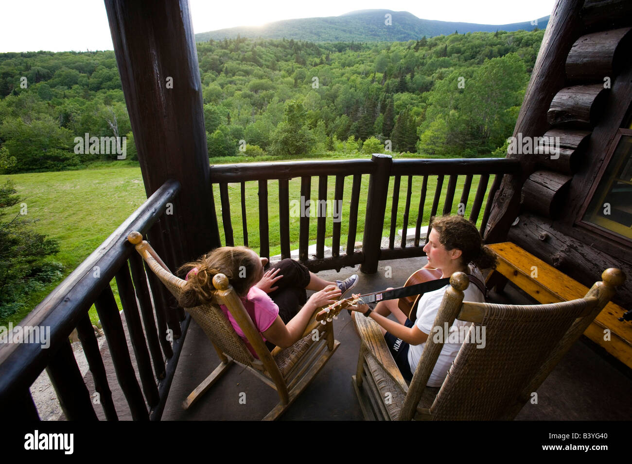 Two young women sing on the porch at the Dartmouth Outing Club's Moosilauke Ravine Lodge Stock Photo