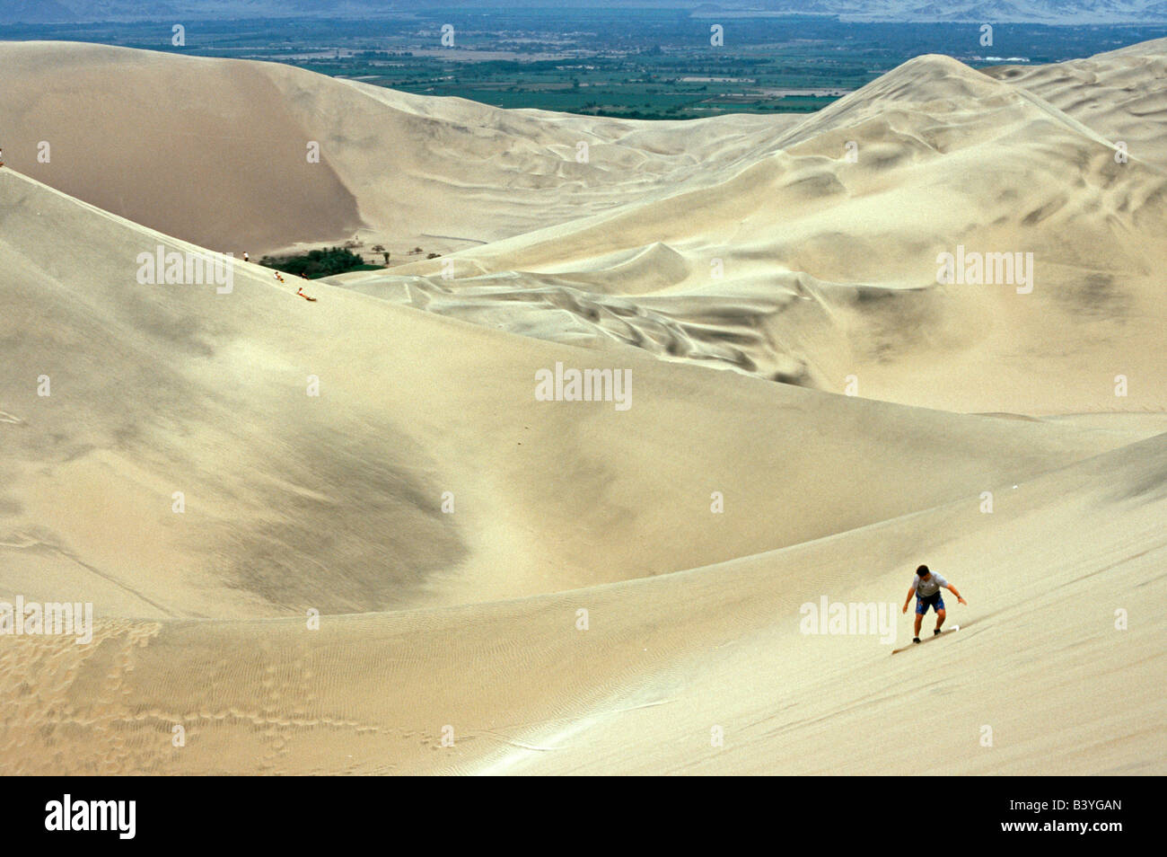A sandboarder rides the coastal desert sands near Ica in southern Peru Stock Photo