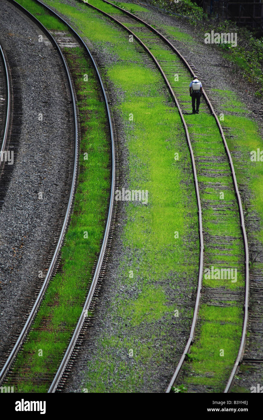 USA, Oregon, Portland. Man spraying to control weeds along railroad