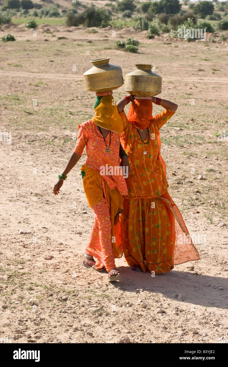 Women on their way to collect water from small water pond. Thar desert, Rajasthan, India. Stock Photo