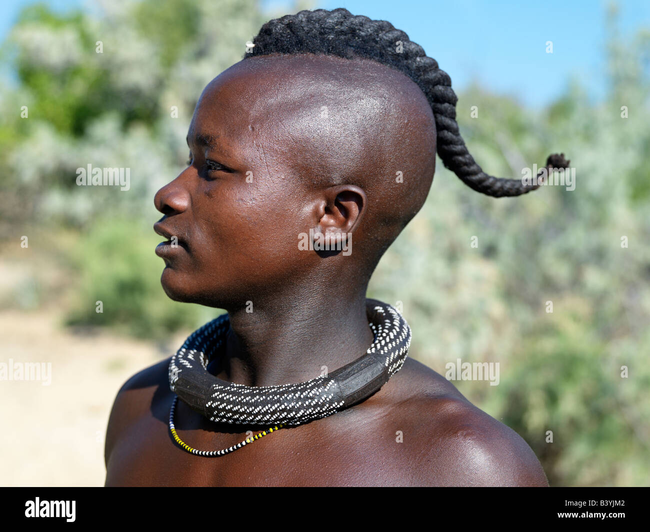 Namibia, Kaokoland. A Himba youth with his hair styled in a long plait, known as ondatu. Once married, he will split the ondatu Stock Photo