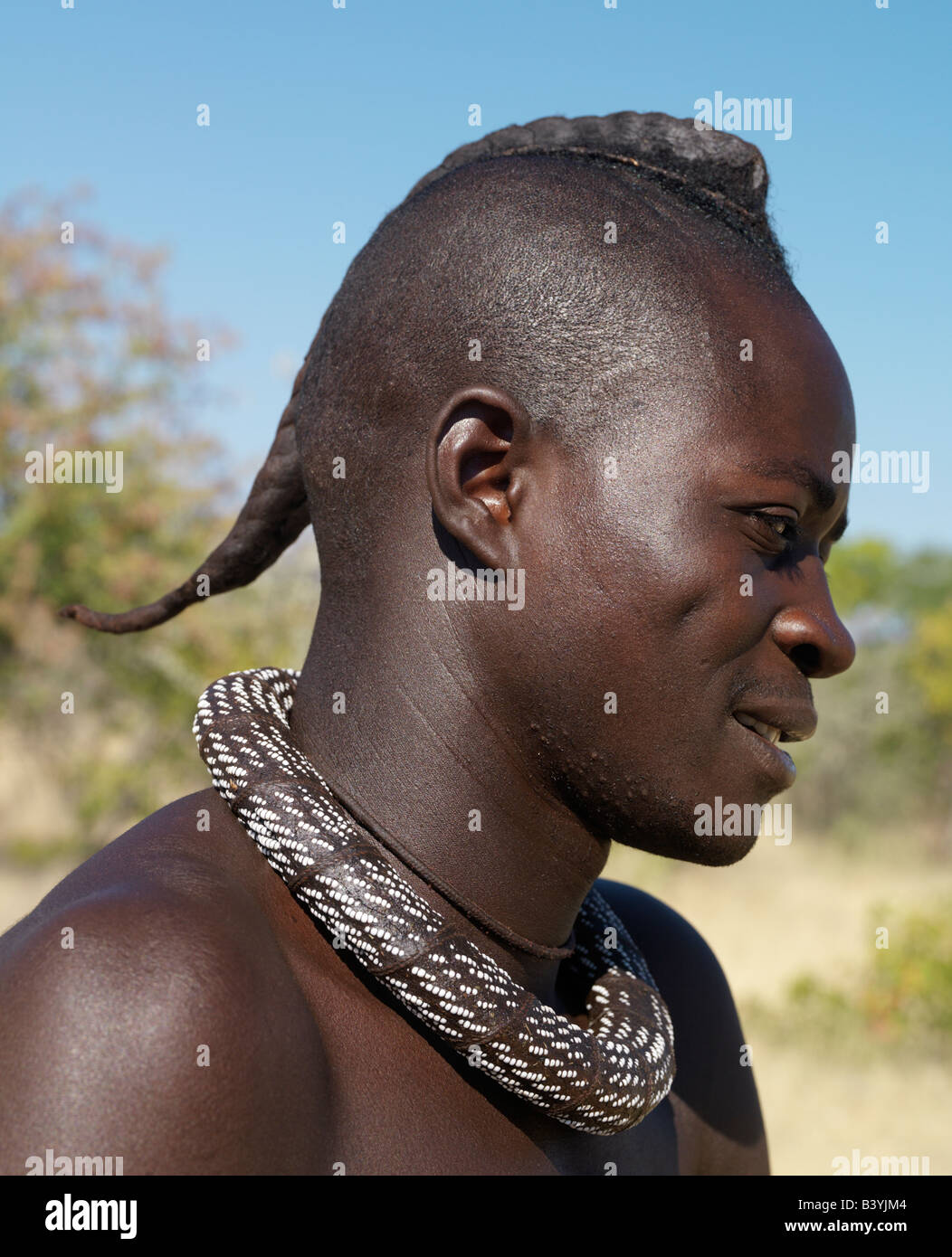 Namibia, Kaokoland. A Himba youth with his hair styled in a long plait, known as ondatu. Once married, he will split the ondatu Stock Photo