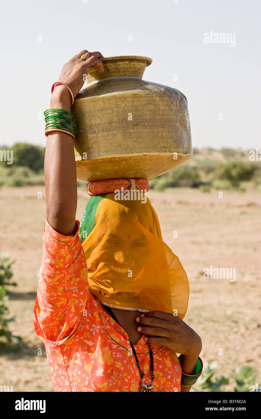 Woman on her way to collect water from small water pond. Thar desert, Rajasthan, India. Stock Photo