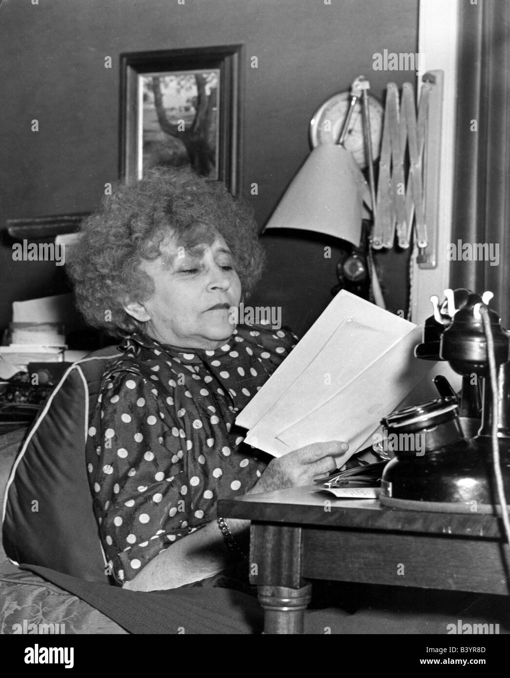Colette, Sidonie - Gabrielle 28.1.1873 - 3.8.1954, French author / writer, sitting, desktop, reading, circa 1950, paper, leaves, sheets, working, telephone set, , Stock Photo