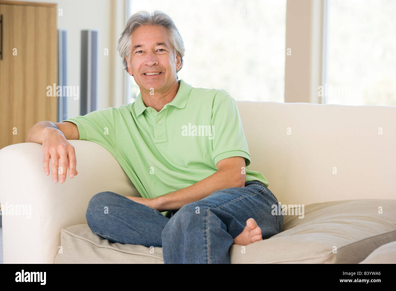 Man sitting in living room smiling Stock Photo