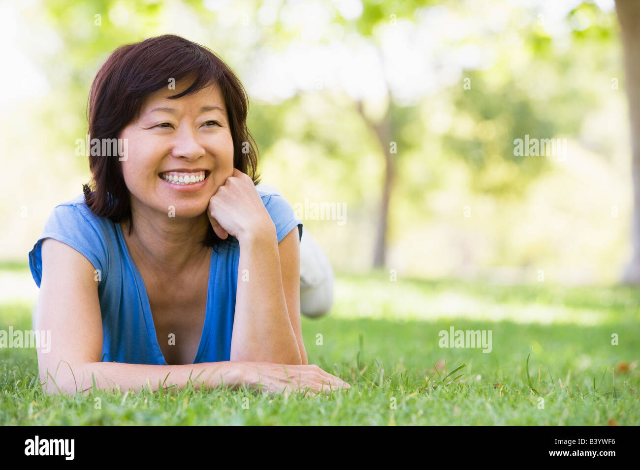 Woman relaxing outdoors smiling Stock Photo - Alamy
