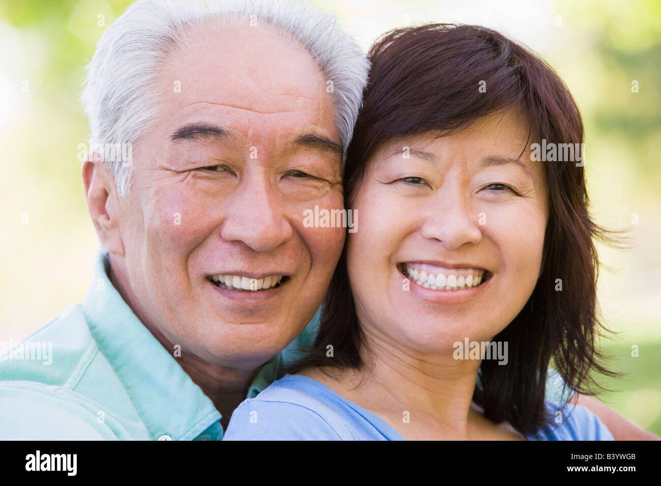 Couple relaxing outdoors in park smiling Stock Photo - Alamy