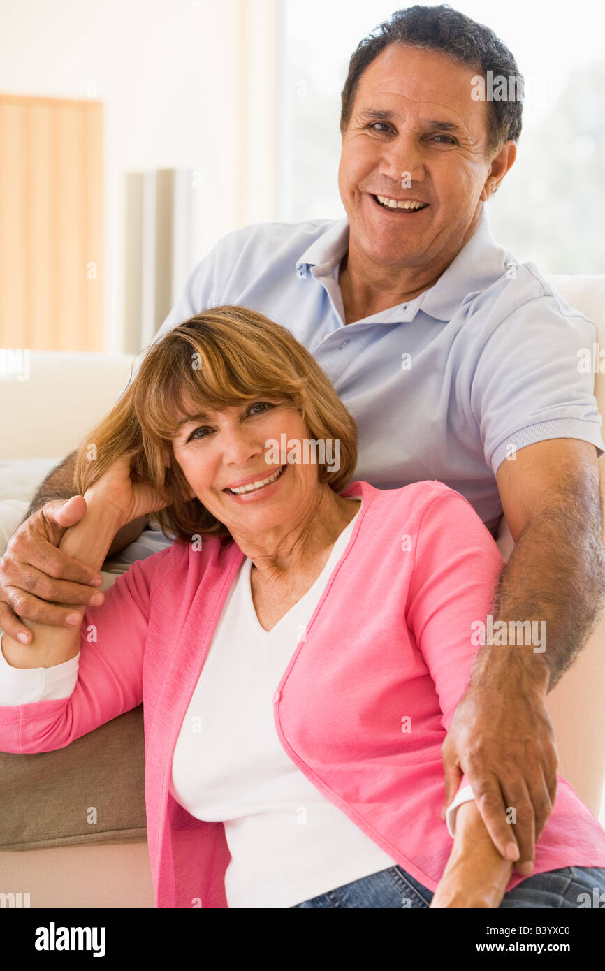 Couple relaxing in living room and smiling Stock Photo - Alamy
