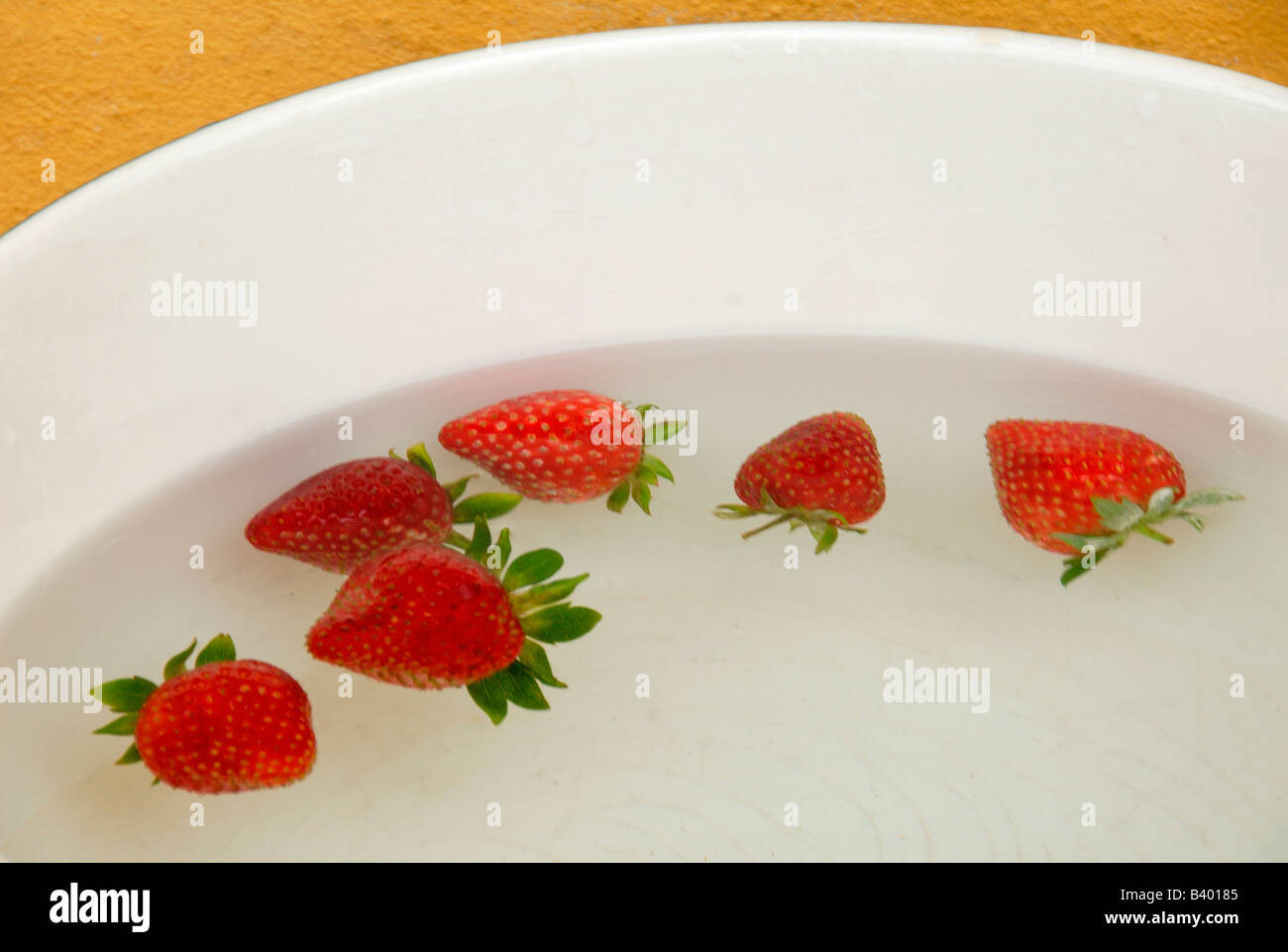 6 fresh strawberries floating in water Stock Photo