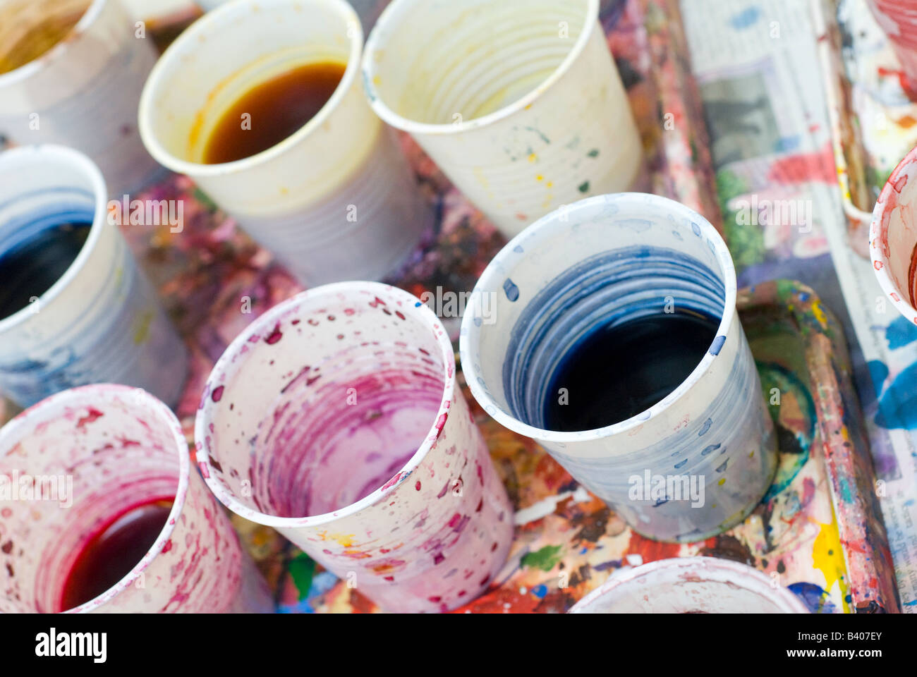 dirty water in plastic cups used to clean paint brushes during an art