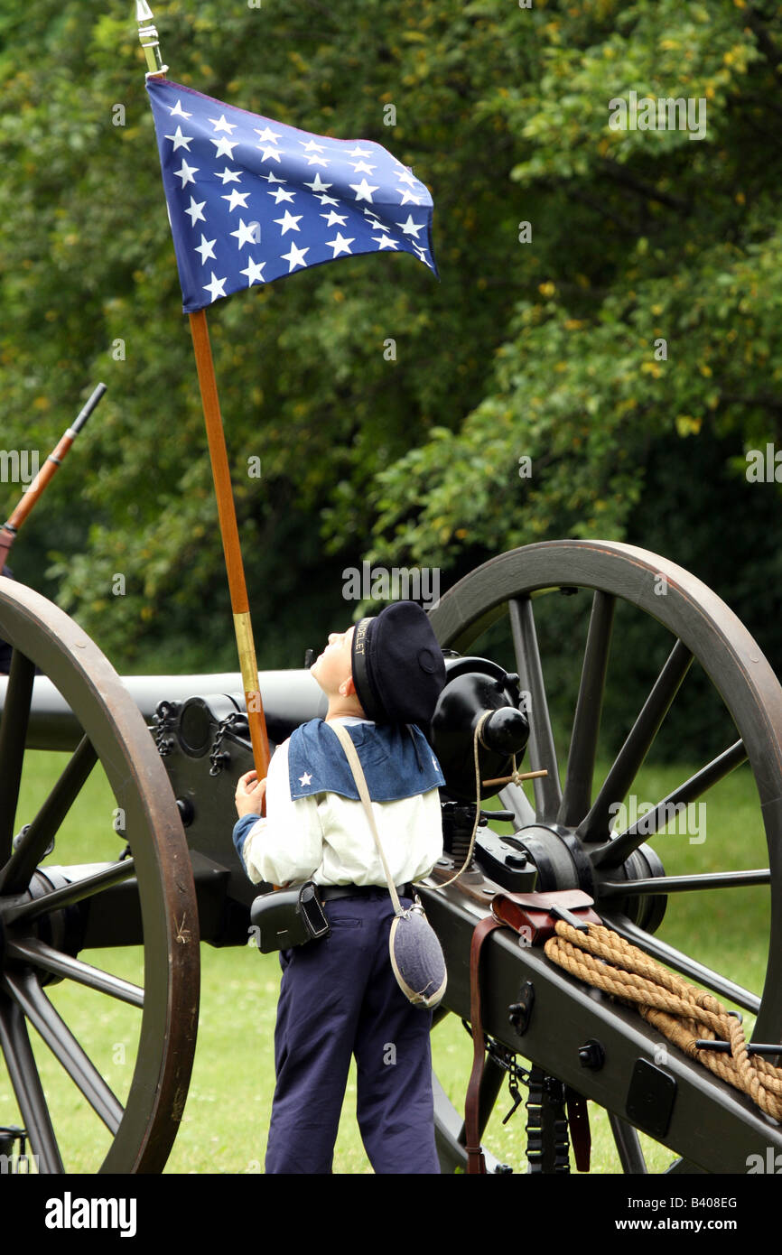 A young boy looking up at the Union flag during a battle at a Civil War Encampment Reenactment Stock Photo