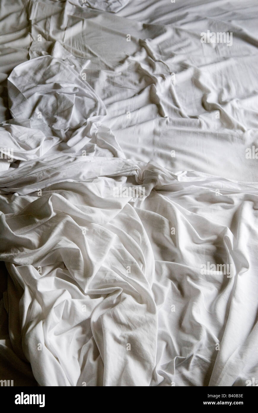Unmade bed white bed sheets crumpled Stock Photo