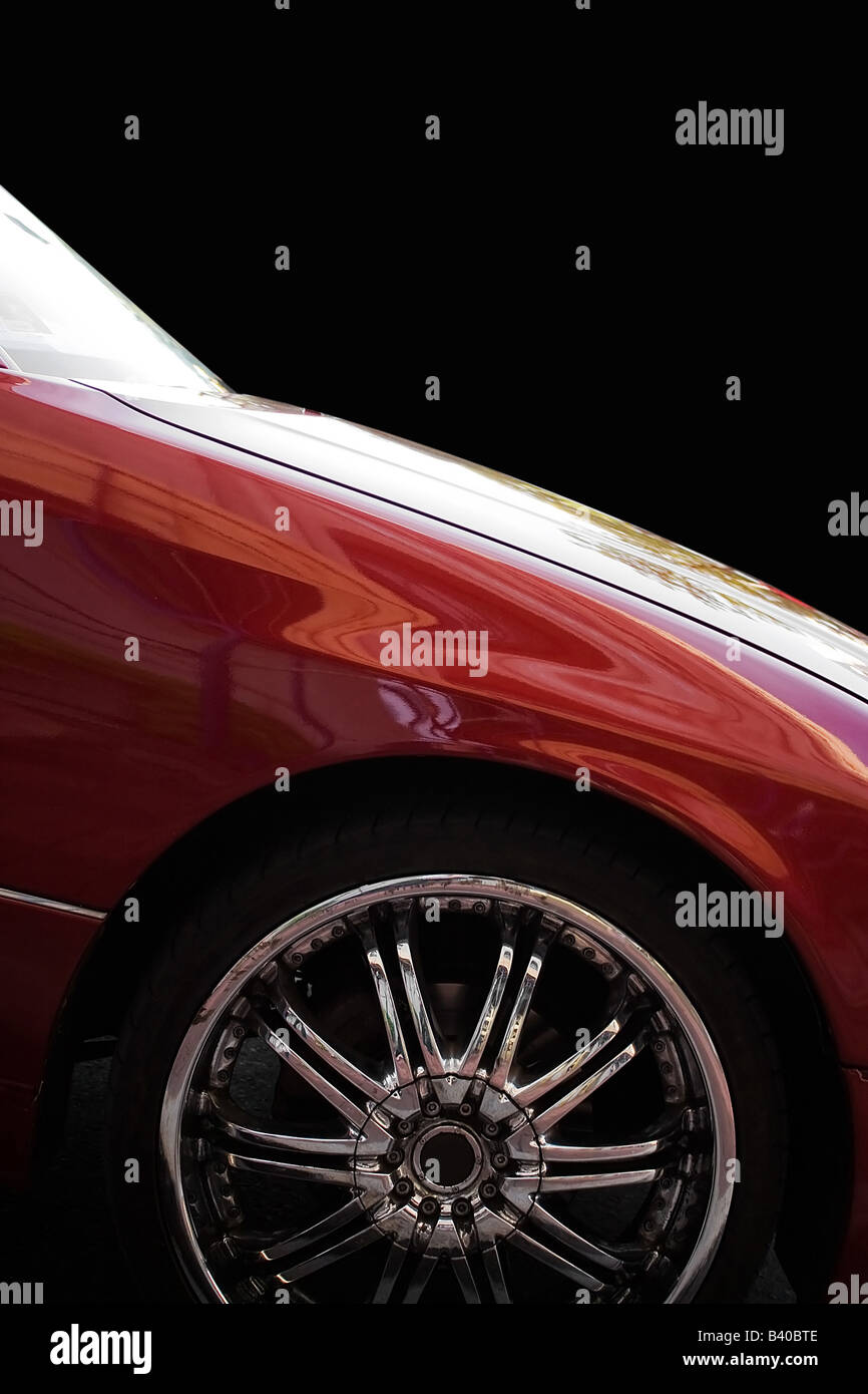 A closeup of a chrome rim on a modern luxury sedan isolated over black Stock Photo