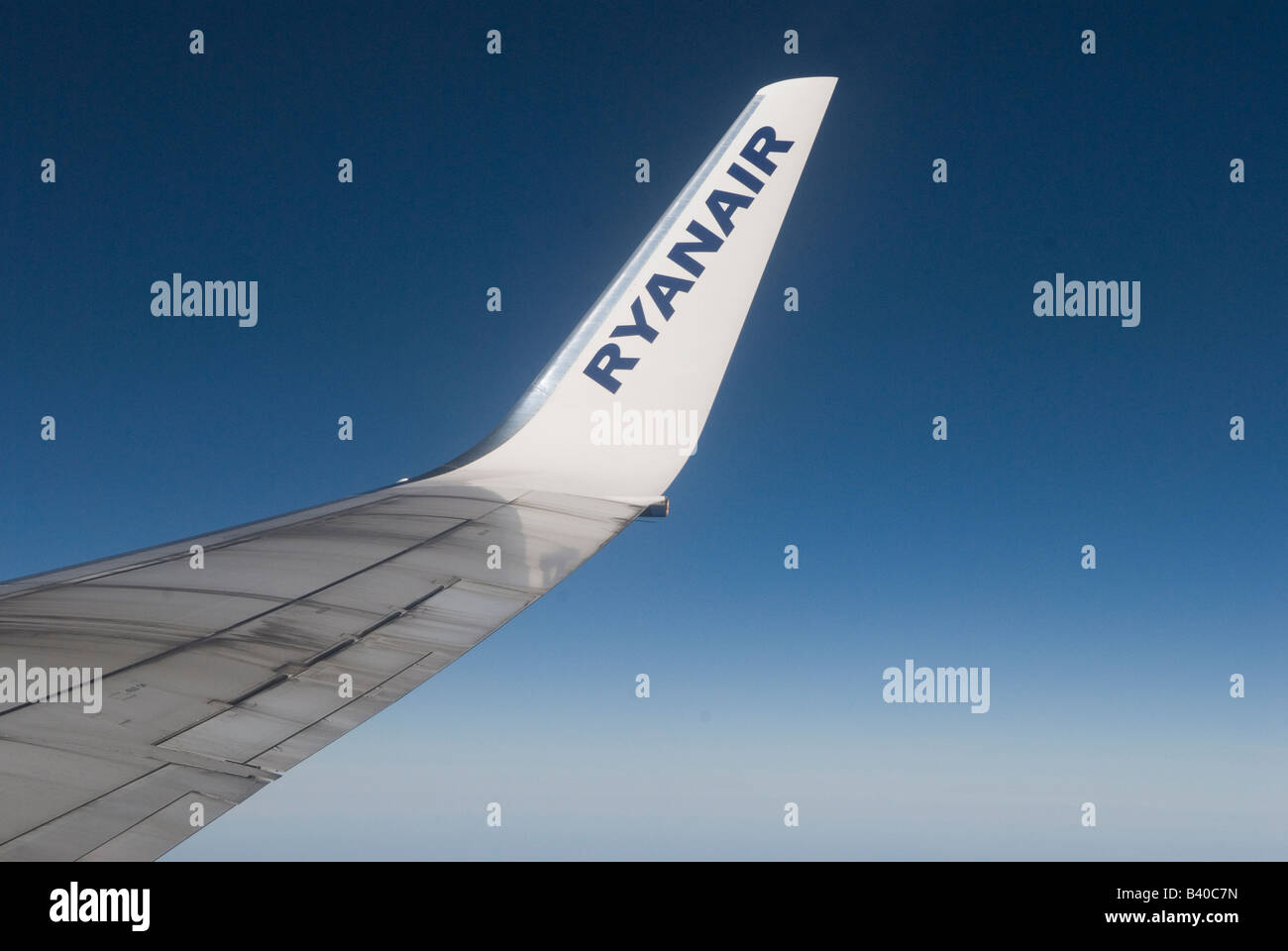 Ryanair Ryan Air wing logo of an Boeing aeroplane looking out of window above cloud level Blue sky HOMER SYKES Stock Photo