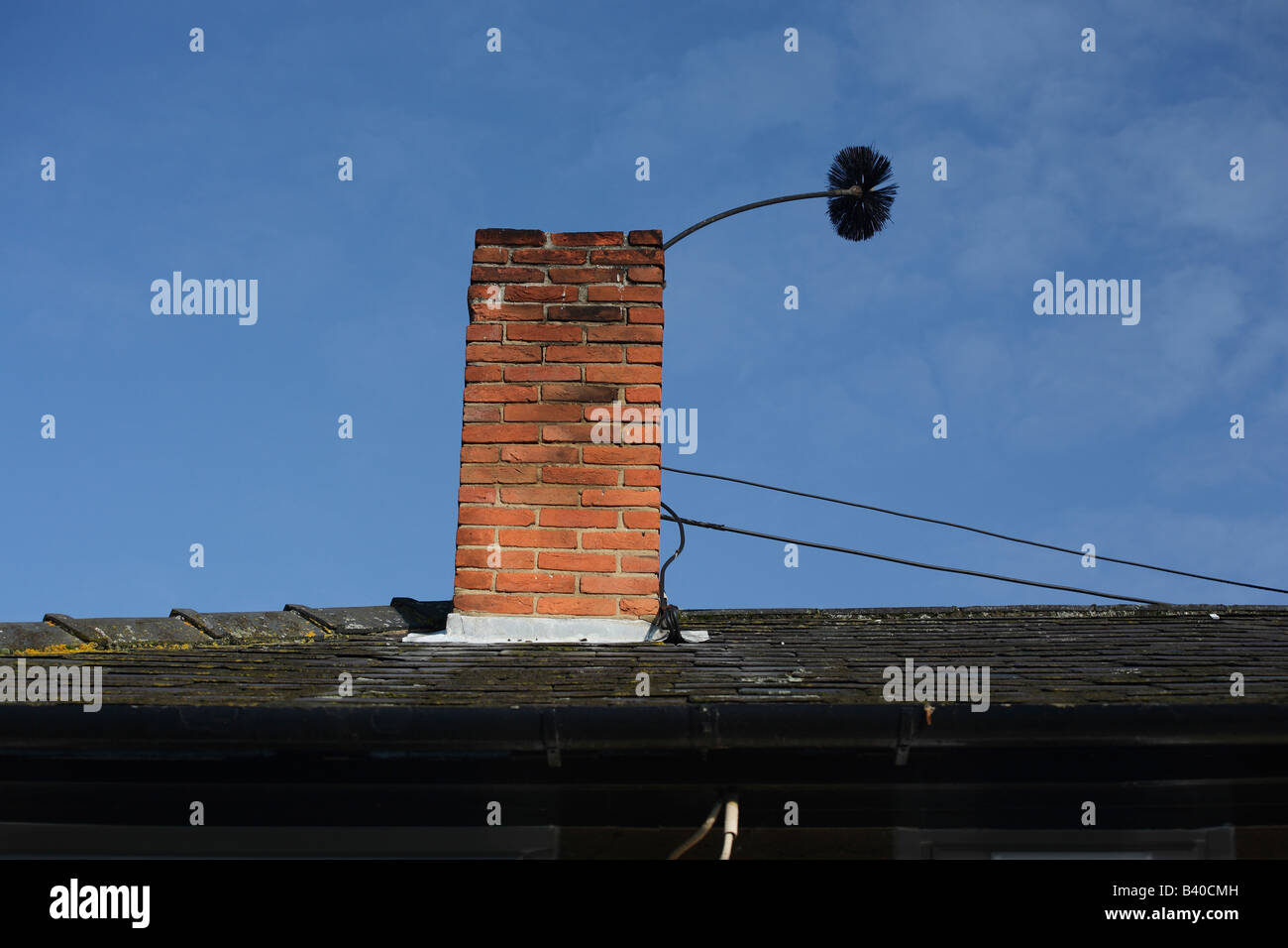 Sweeps brush poking out of a chimney. Stock Photo