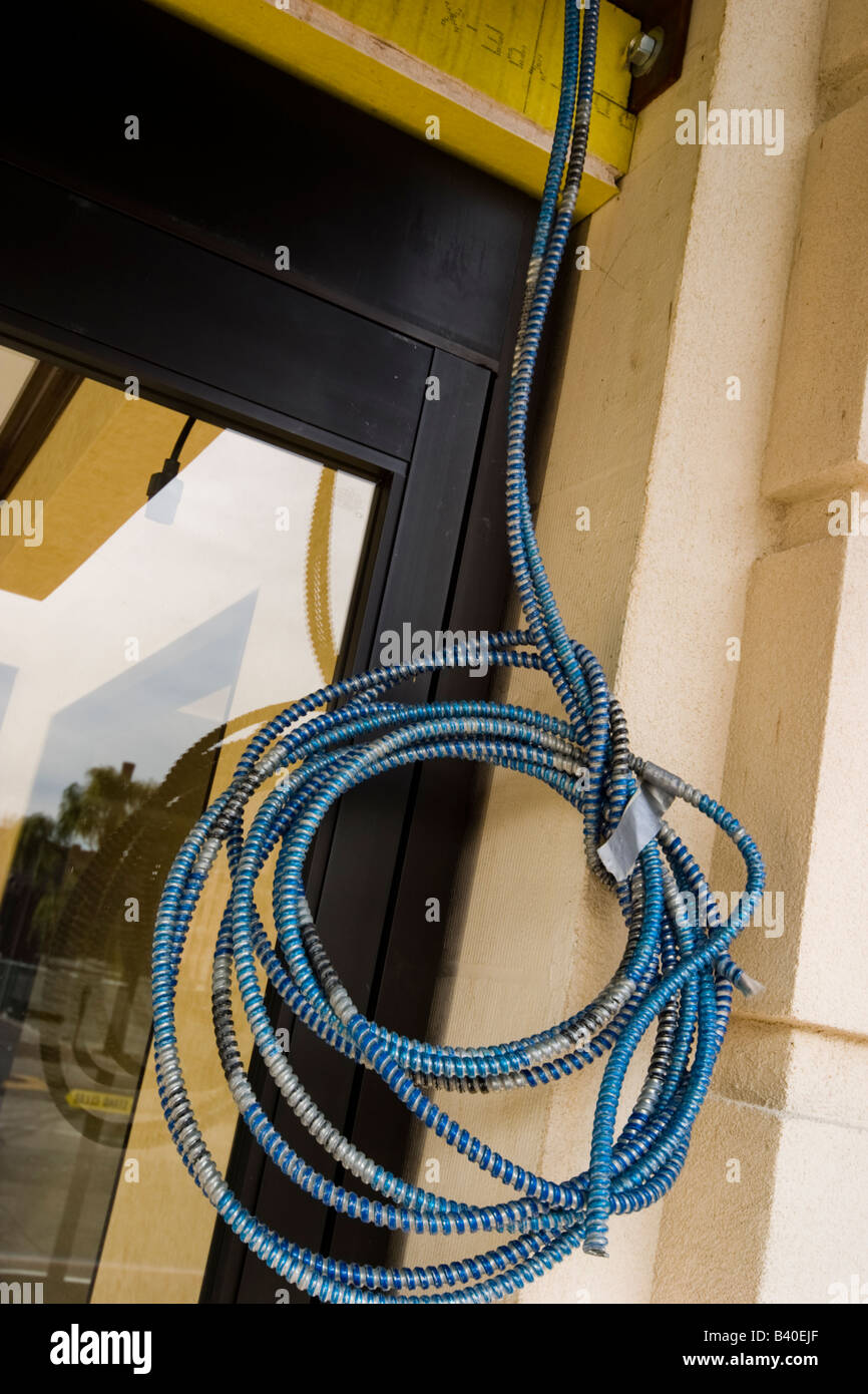 Coiled electrical cable hanging outside a building Stock Photo Alamy