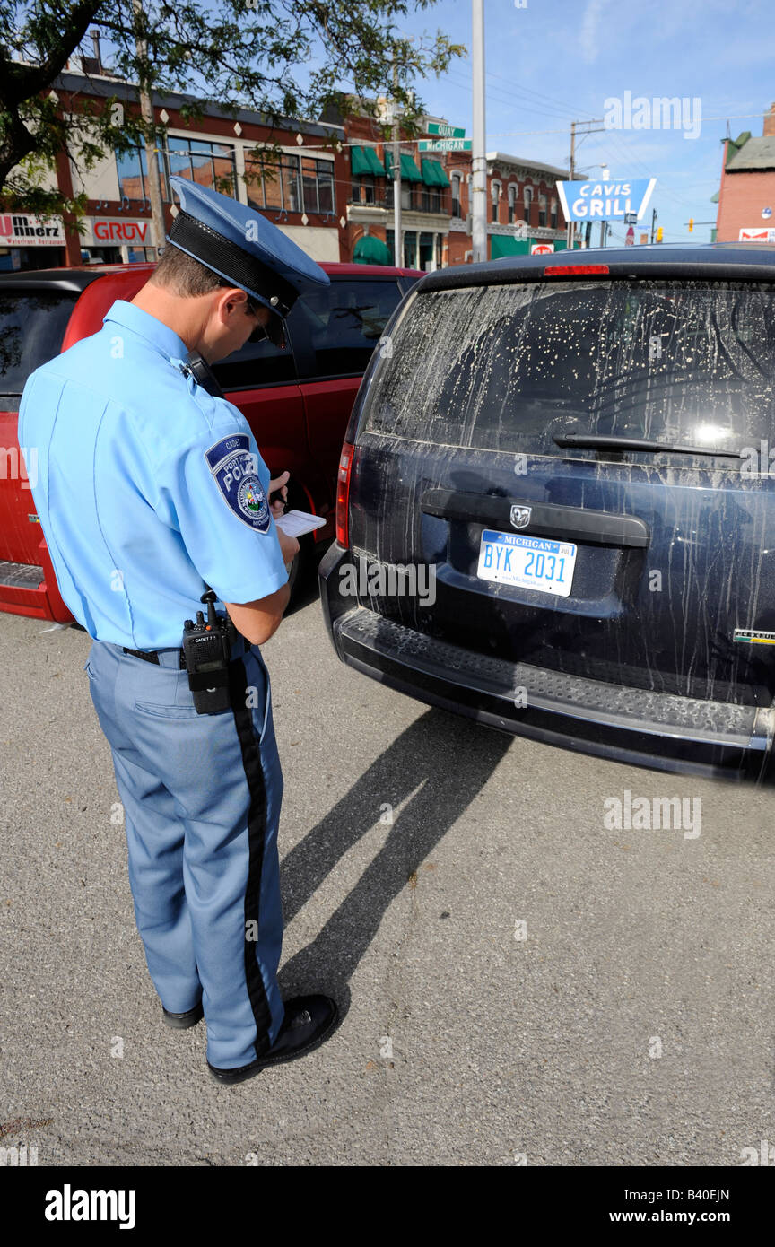 Police officer writes a ticket for parking violation Stock Photo