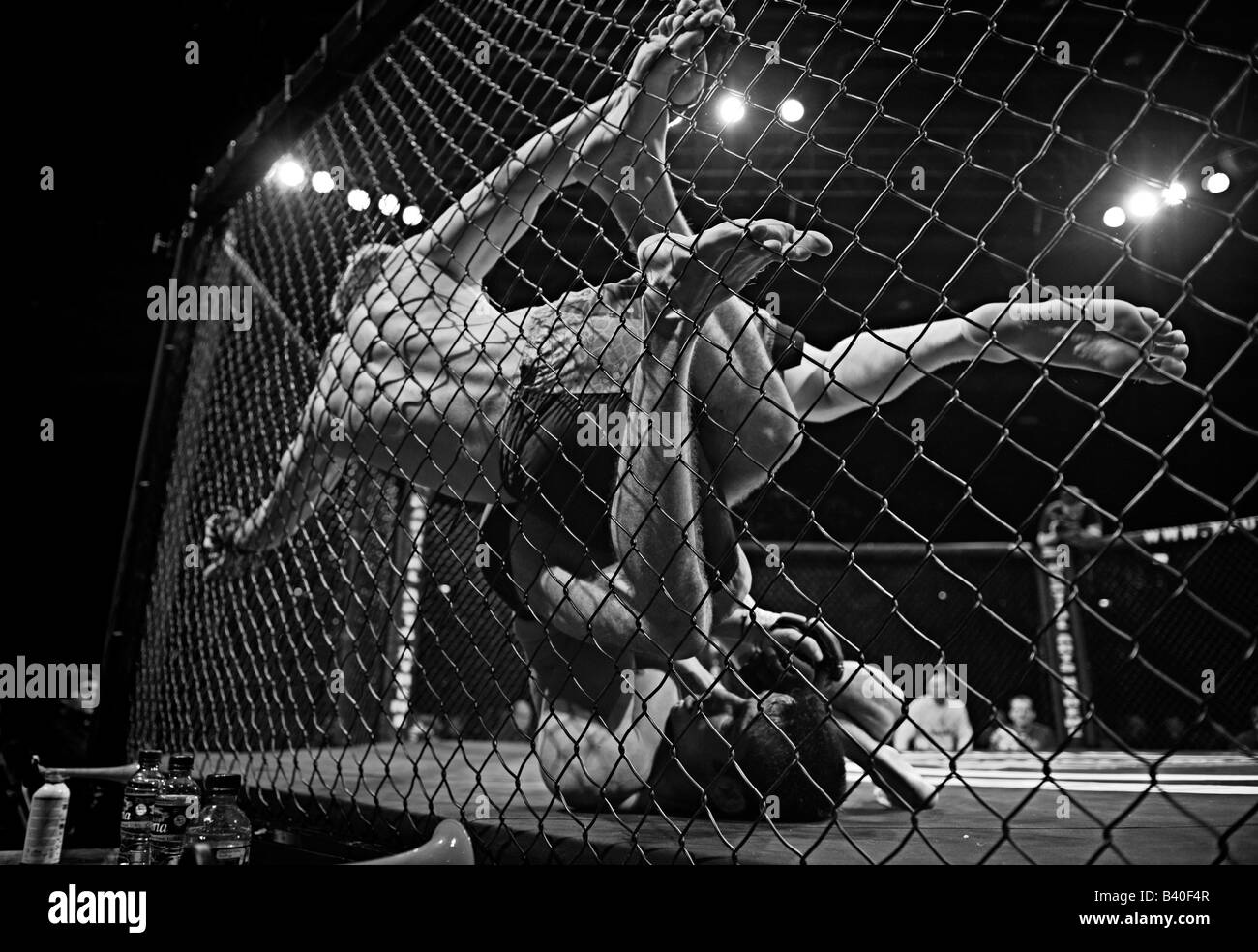 Two cage fighters grapple in the Octagon Stock Photo