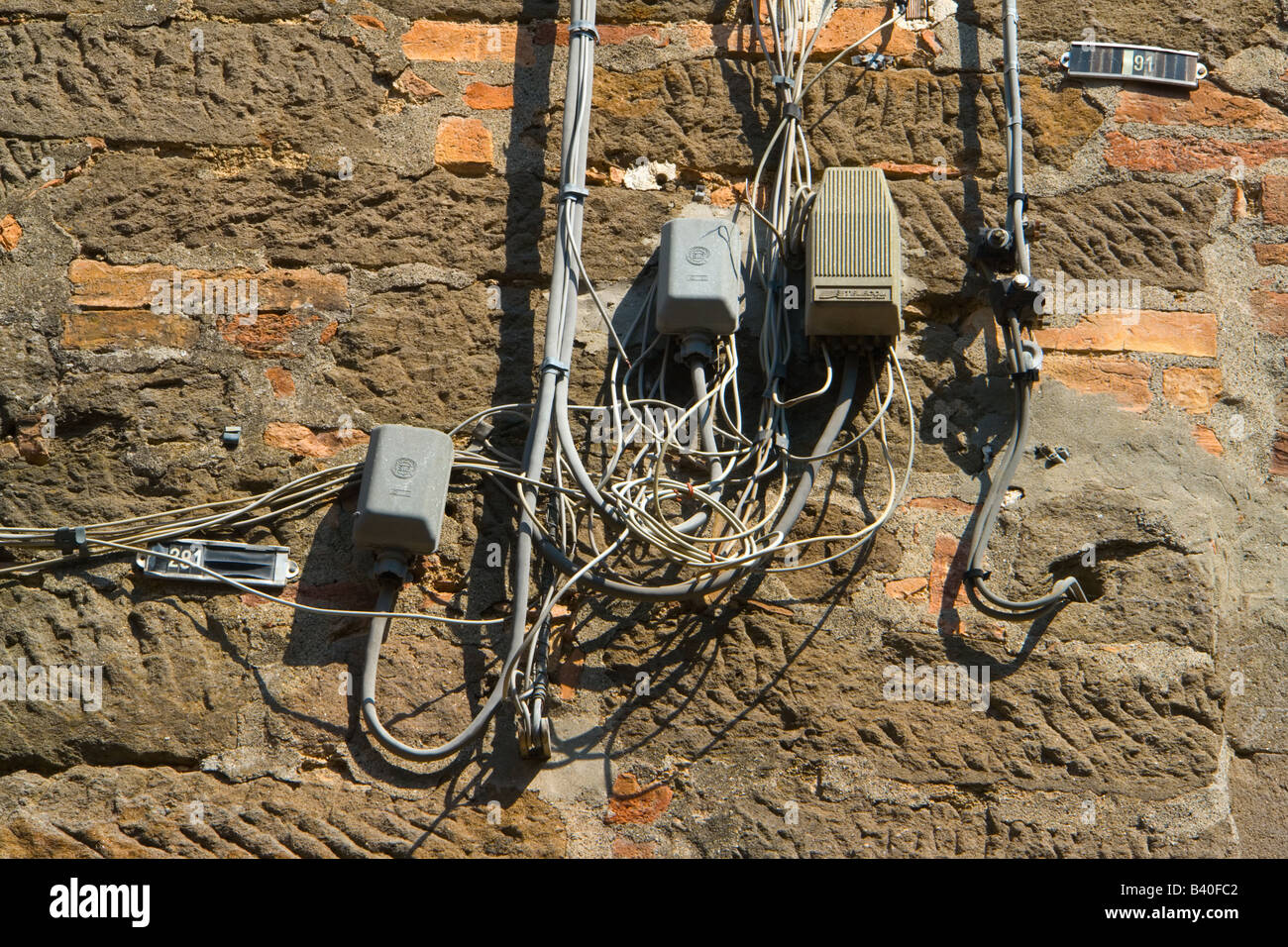 Wiring on the house wall in Italy Stock Photo - Alamy