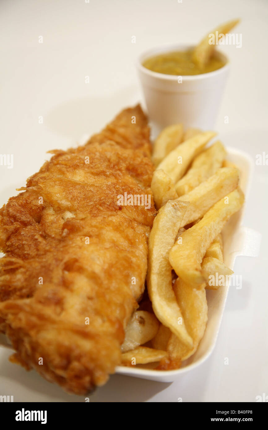 Fish and chips with a chip dip into curry sauce Stock Photo Alamy