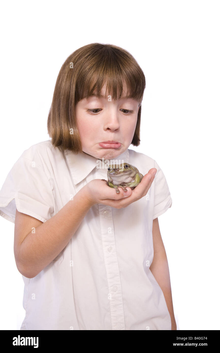 Young girl holding a frog and making a face isolated on white Stock Photo