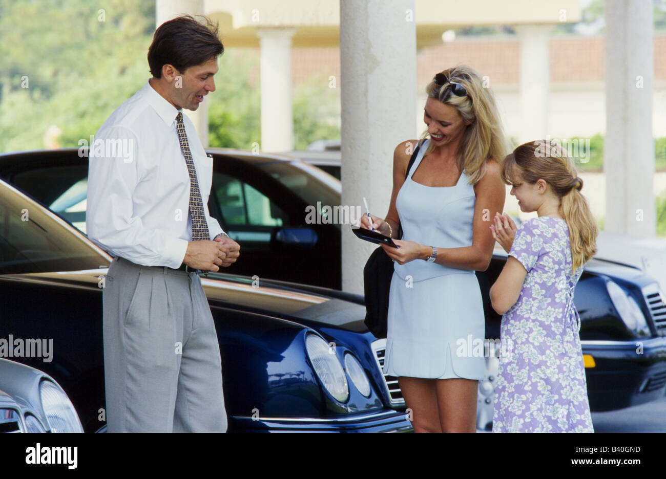 Young woman and child purchasing car from salesman, Miami Stock Photo