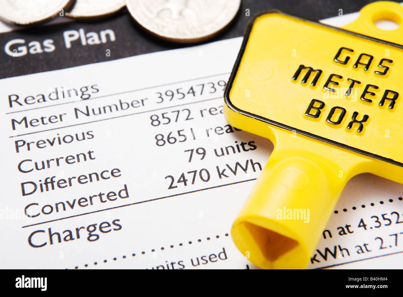 Gas bill with meter key and coins to illustrate rising energy costs ...