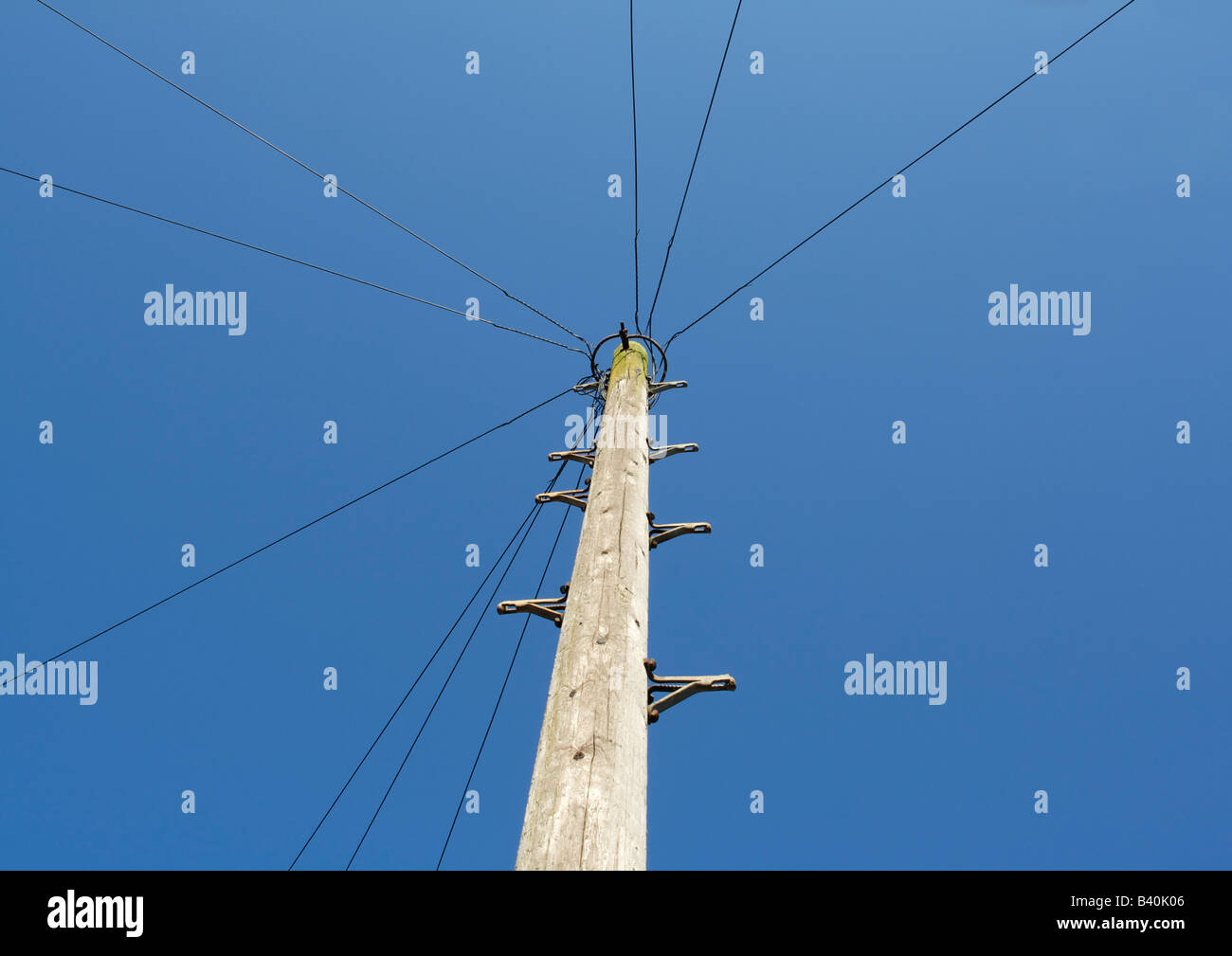 Wooden telegraph pole against blue sky Stock Photo