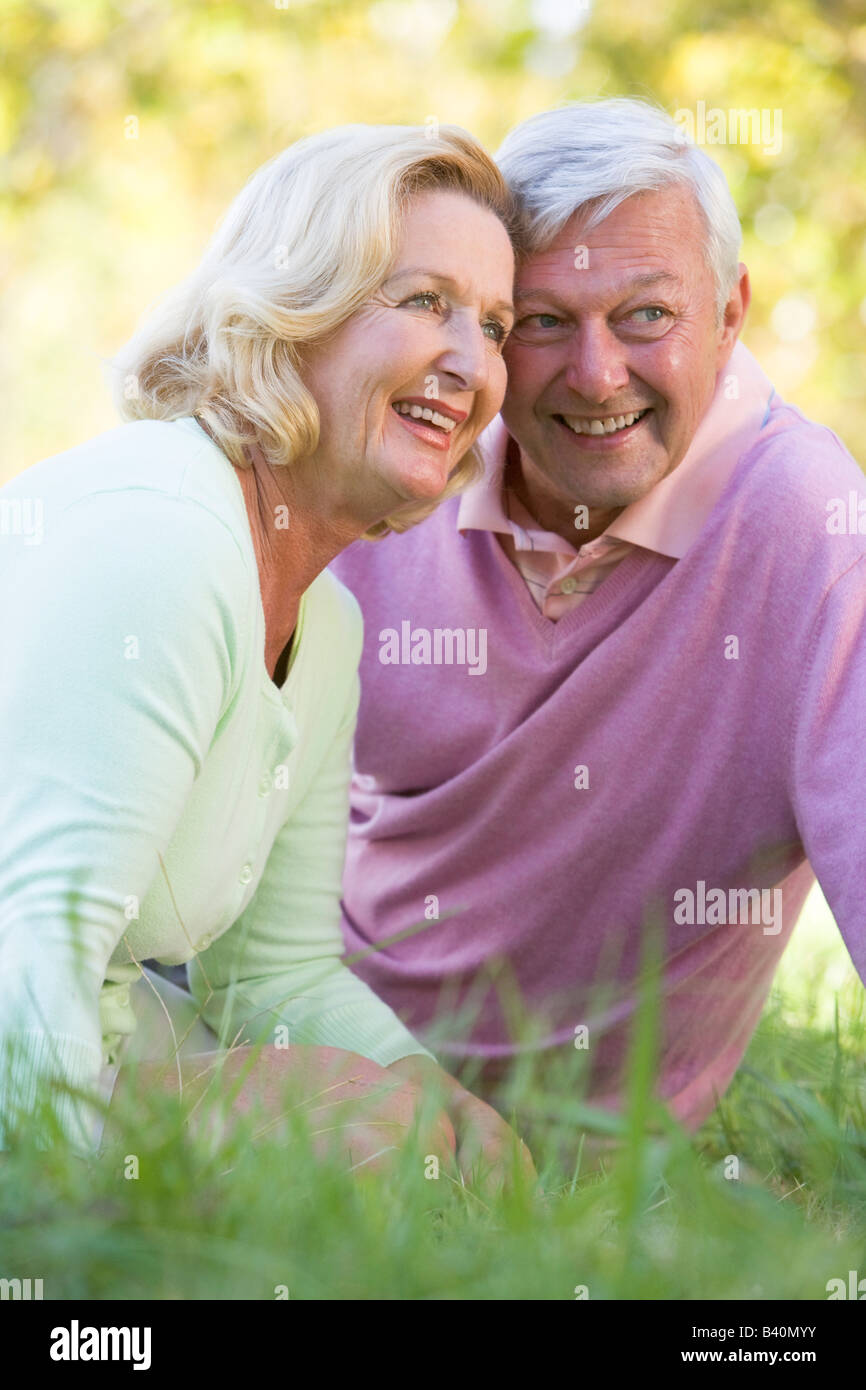 Couple relaxing in park smiling Stock Photo